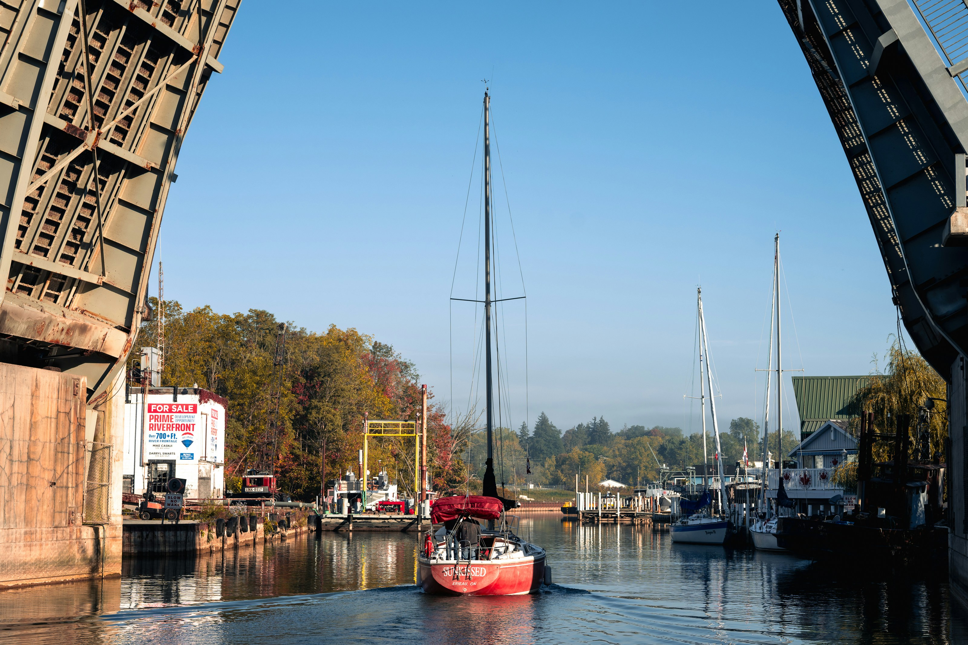 Das Segelboot fährt durch eine offene Zugbrücke auf einem Kanal.