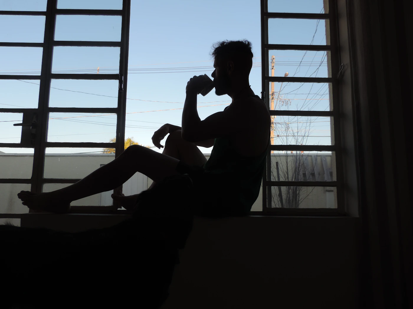 Person mit Kaffee am Fenster als Symbol für eine eingeübte Morgenroutine