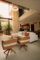 Modern living room with white sofa and wooden chairs.