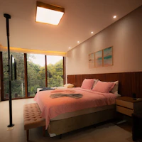 Bedroom with large windows and forest view