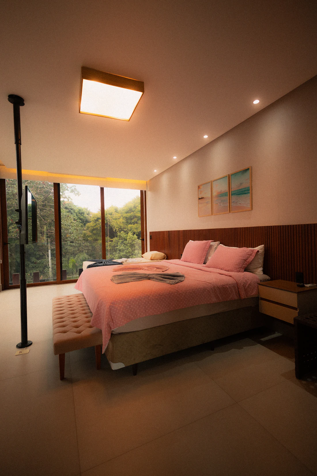 Suíte com janela ampla voltada para a mata