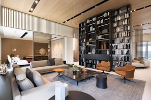 Modern living room with large bookshelf and comfortable seating.