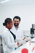 Two scientists working with test tubes in a lab.