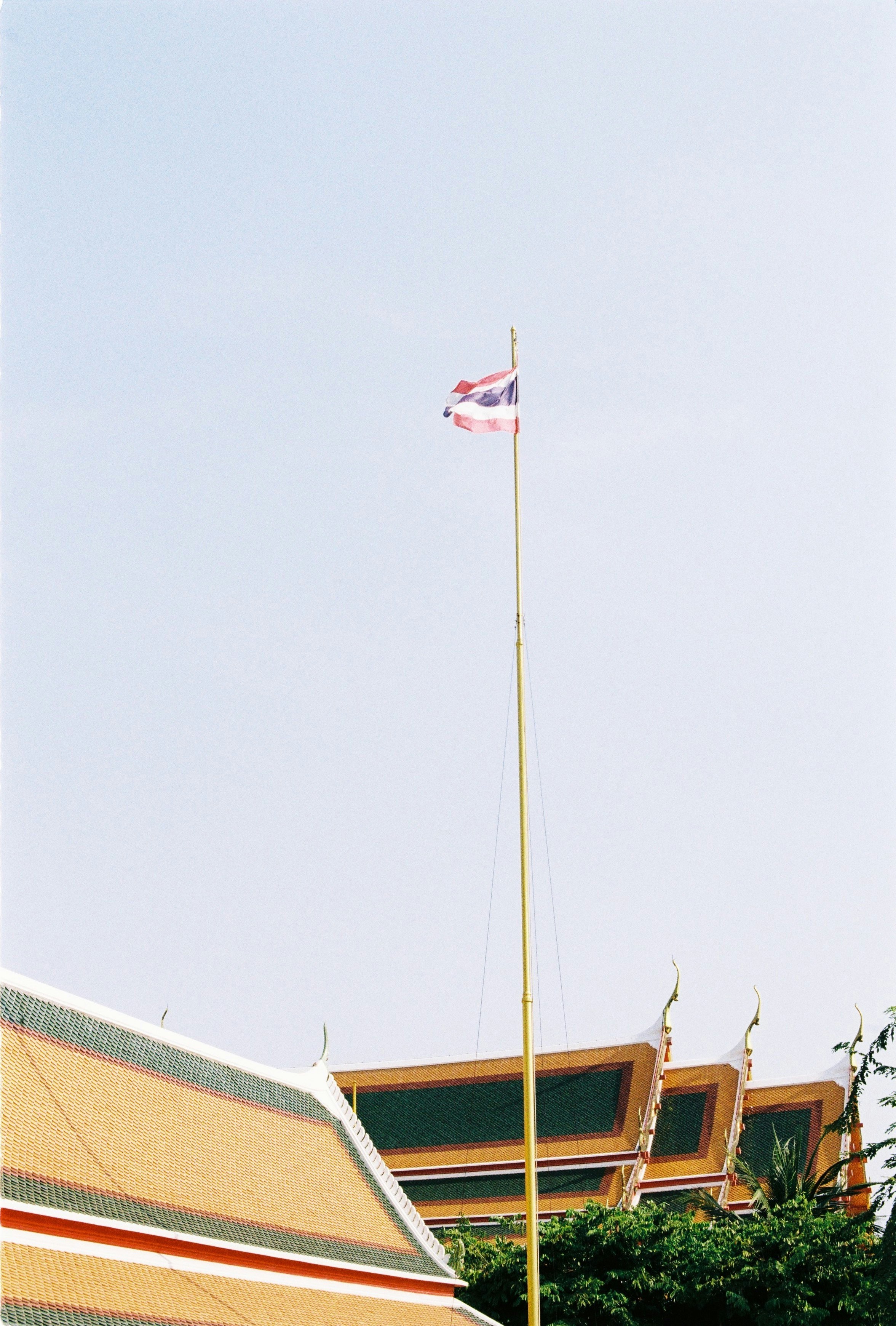 Thai flag flying high above temple roofs