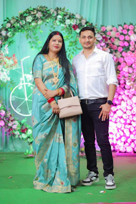 Couple posing in front of a floral backdrop
