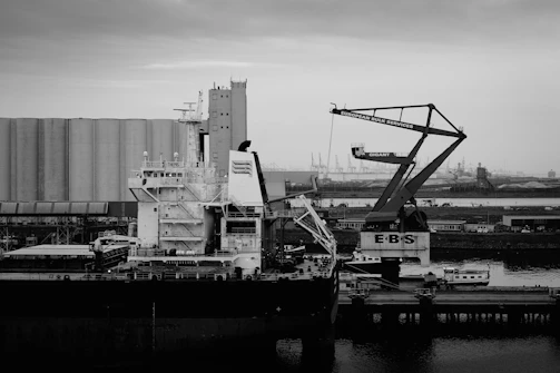 Cargo ship docked at industrial port with cranes