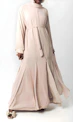 Woman in elegant beige abaya with intricate embroidery.