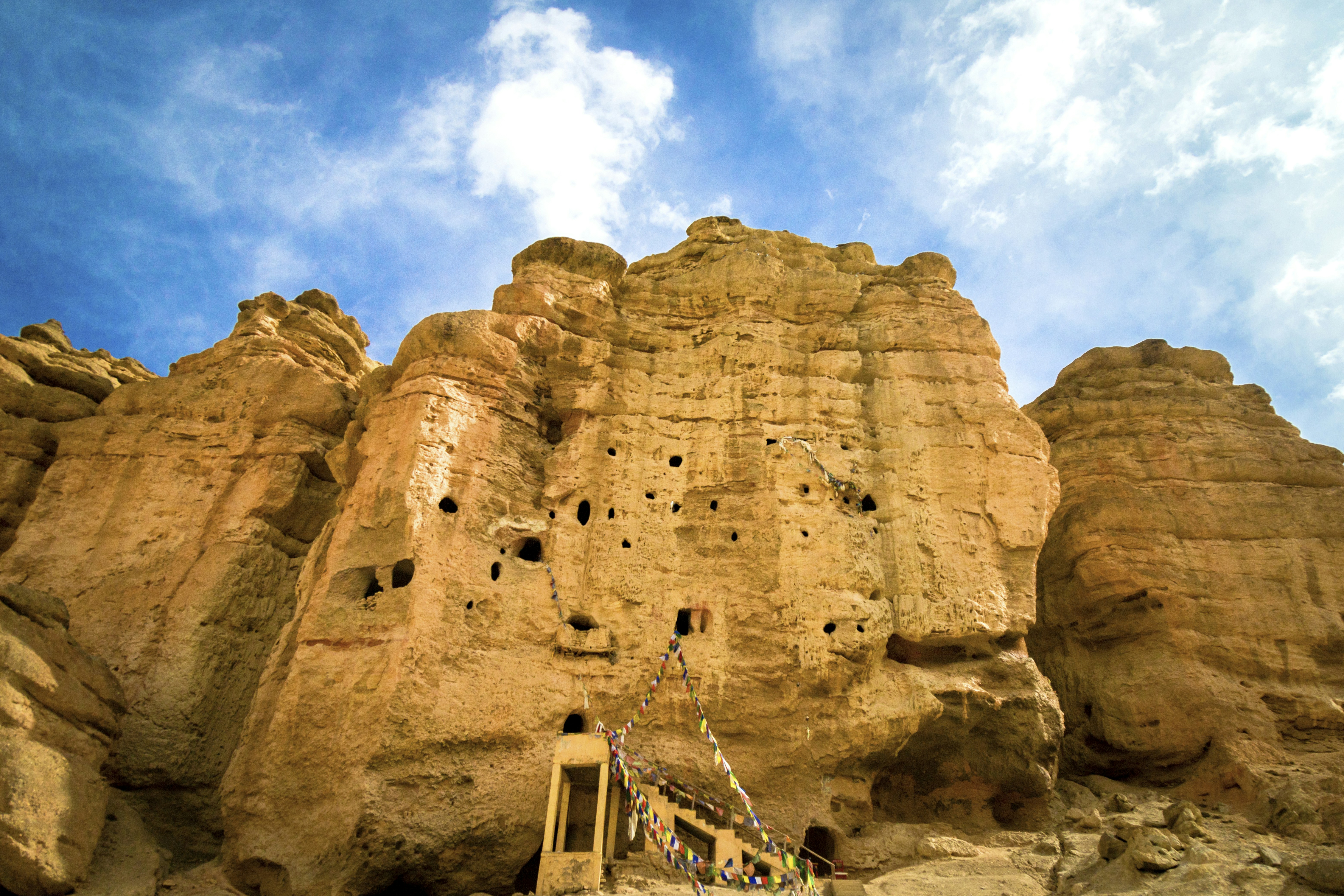 Ancient cave dwellings carved into a sandstone cliff.