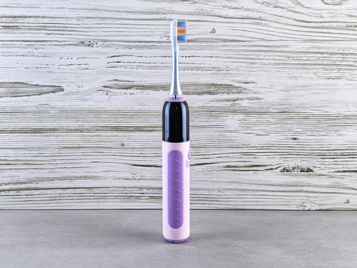 İllüstratif görsel: A purple electric toothbrush on a gray surface.