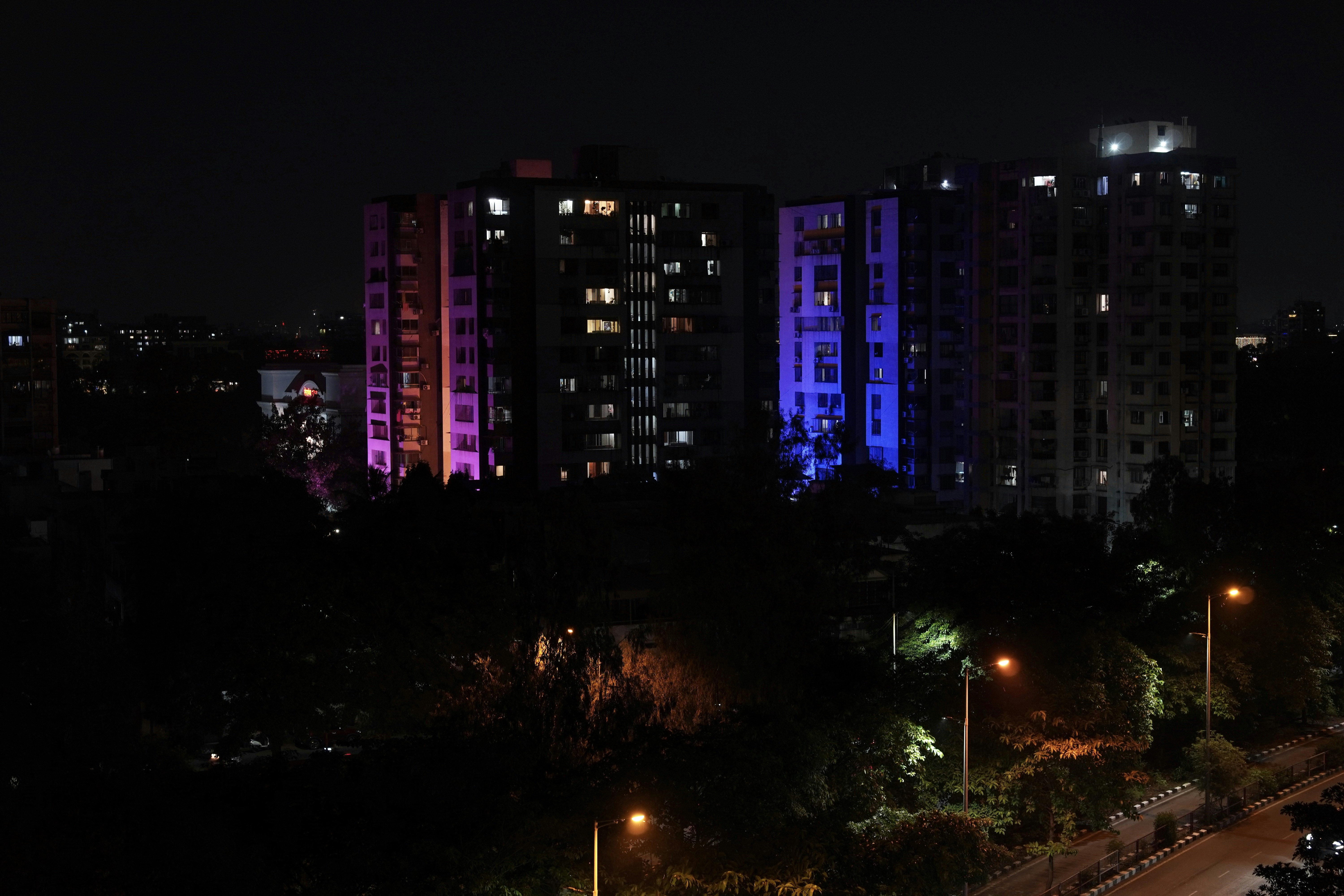 Apartment buildings lit up at night with colorful lights