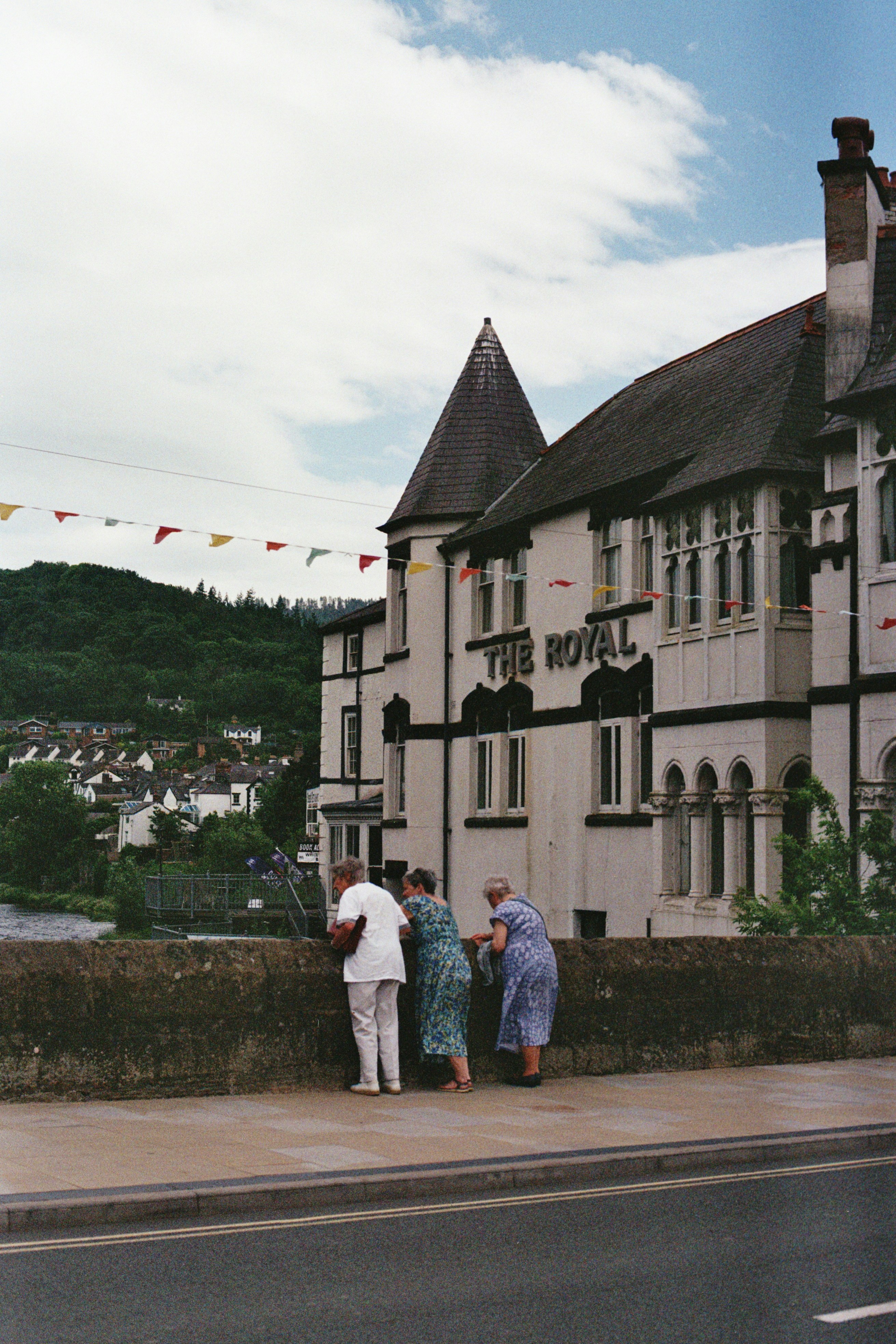 Trois femmes regardent par-dessus un mur le bâtiment royal.