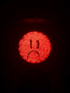 A red light with a sad face drawn on it.