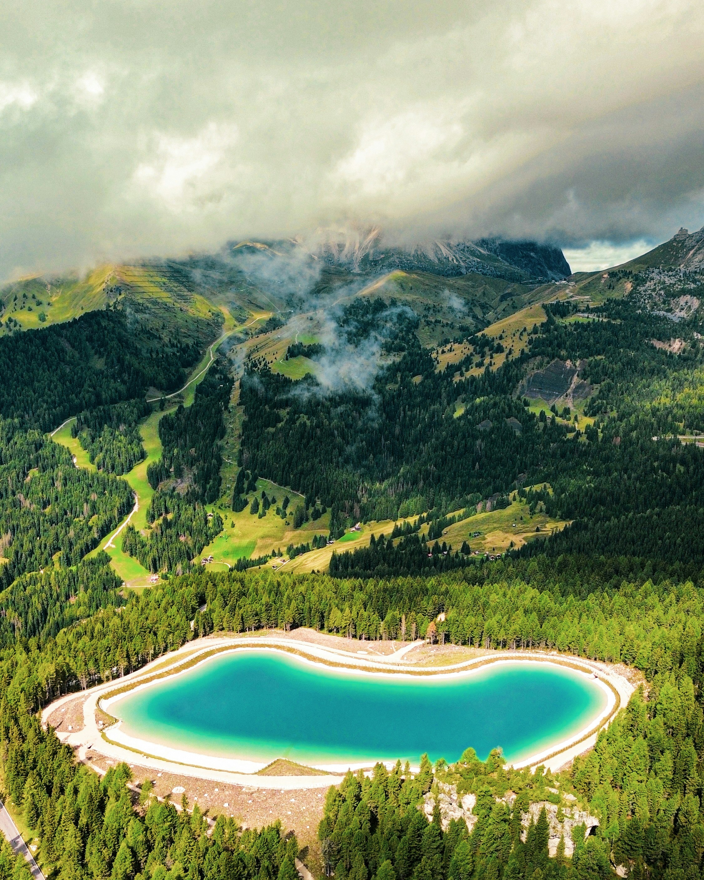 Lago turquesa rodeado de pinos y montañas.