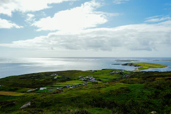 Coastal village with green hills and calm sea