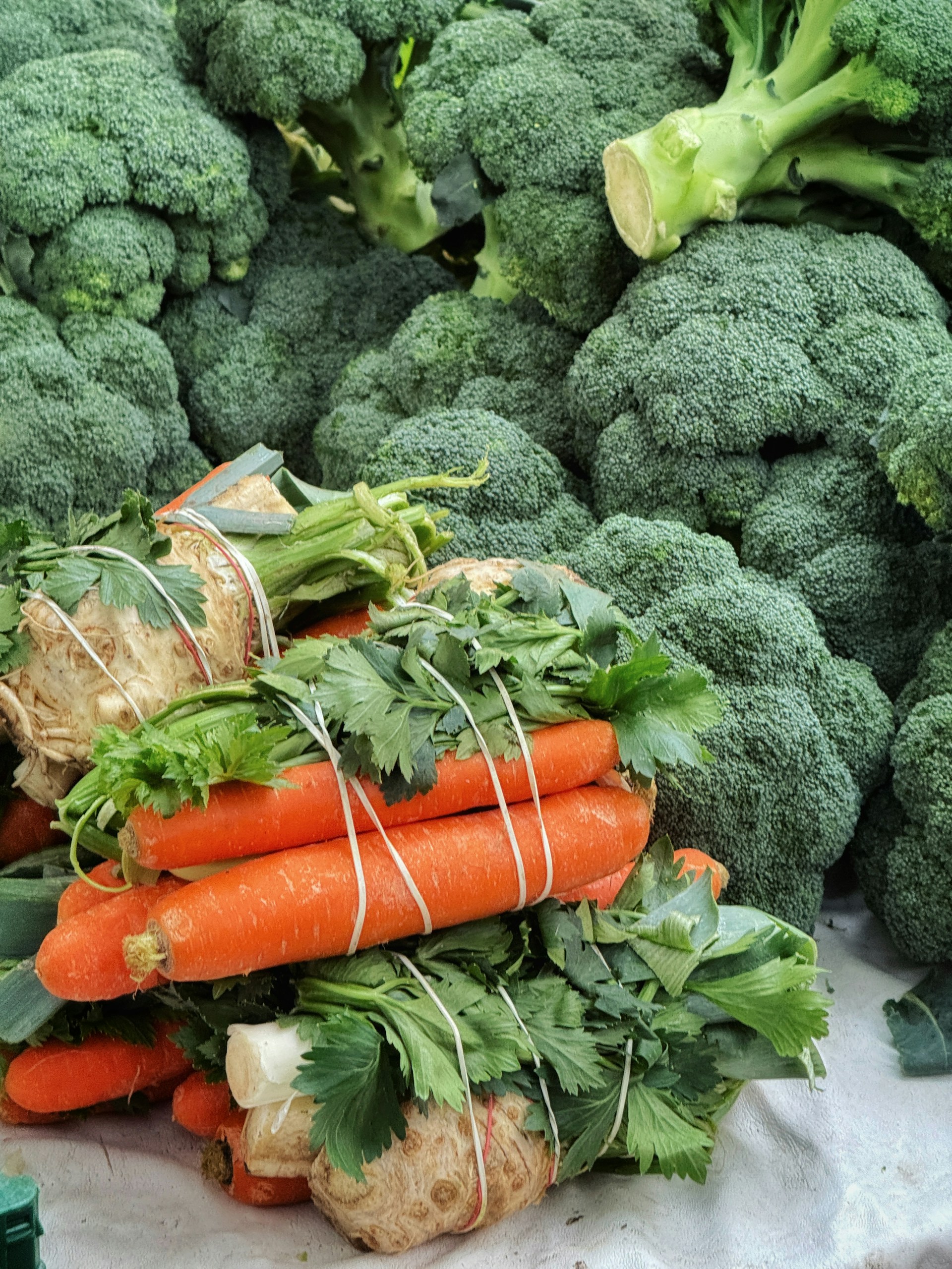 Bundles of carrots, celery, and broccoli at the market