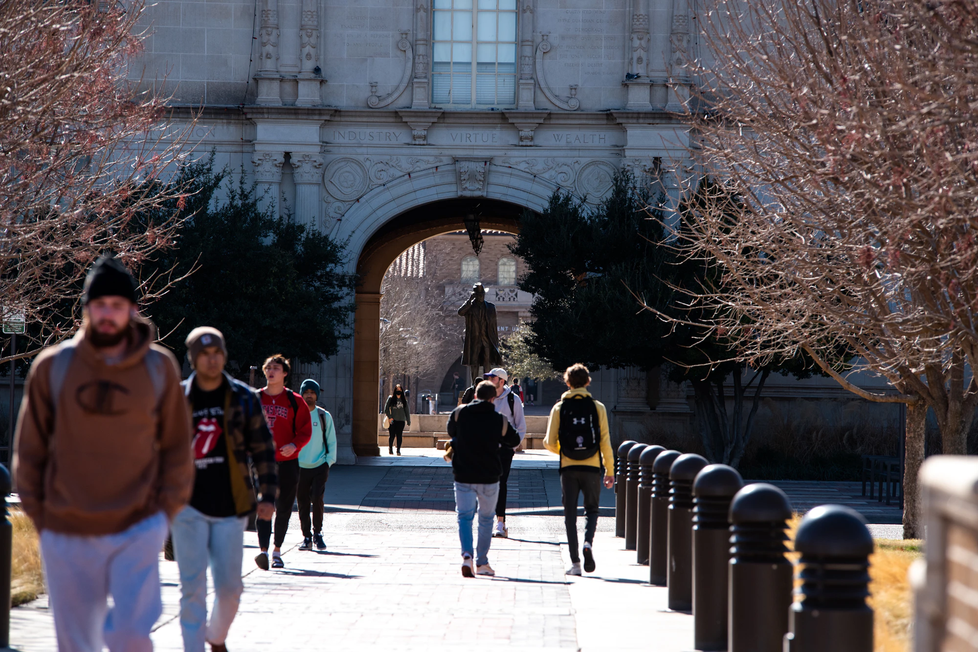 Students walking through the archway into the main campus