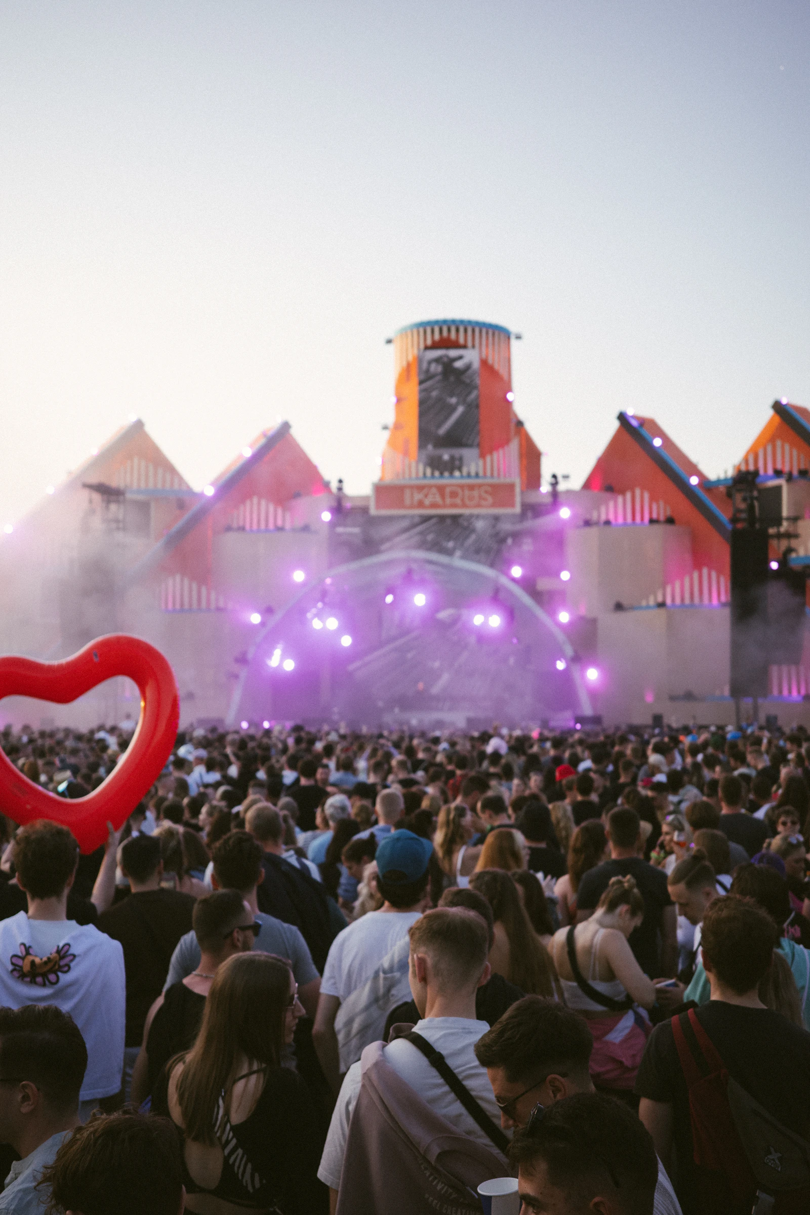 Crowd at an outdoor music festival with stage