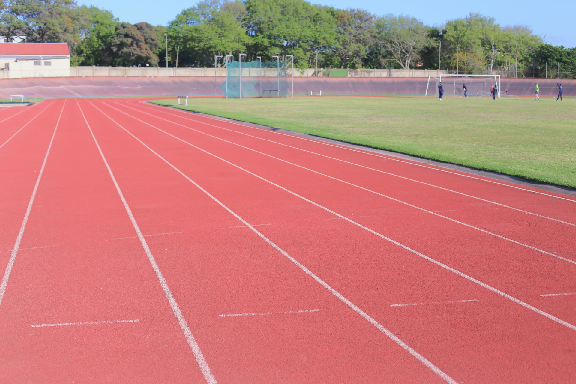 Red running track with green field and stadium.