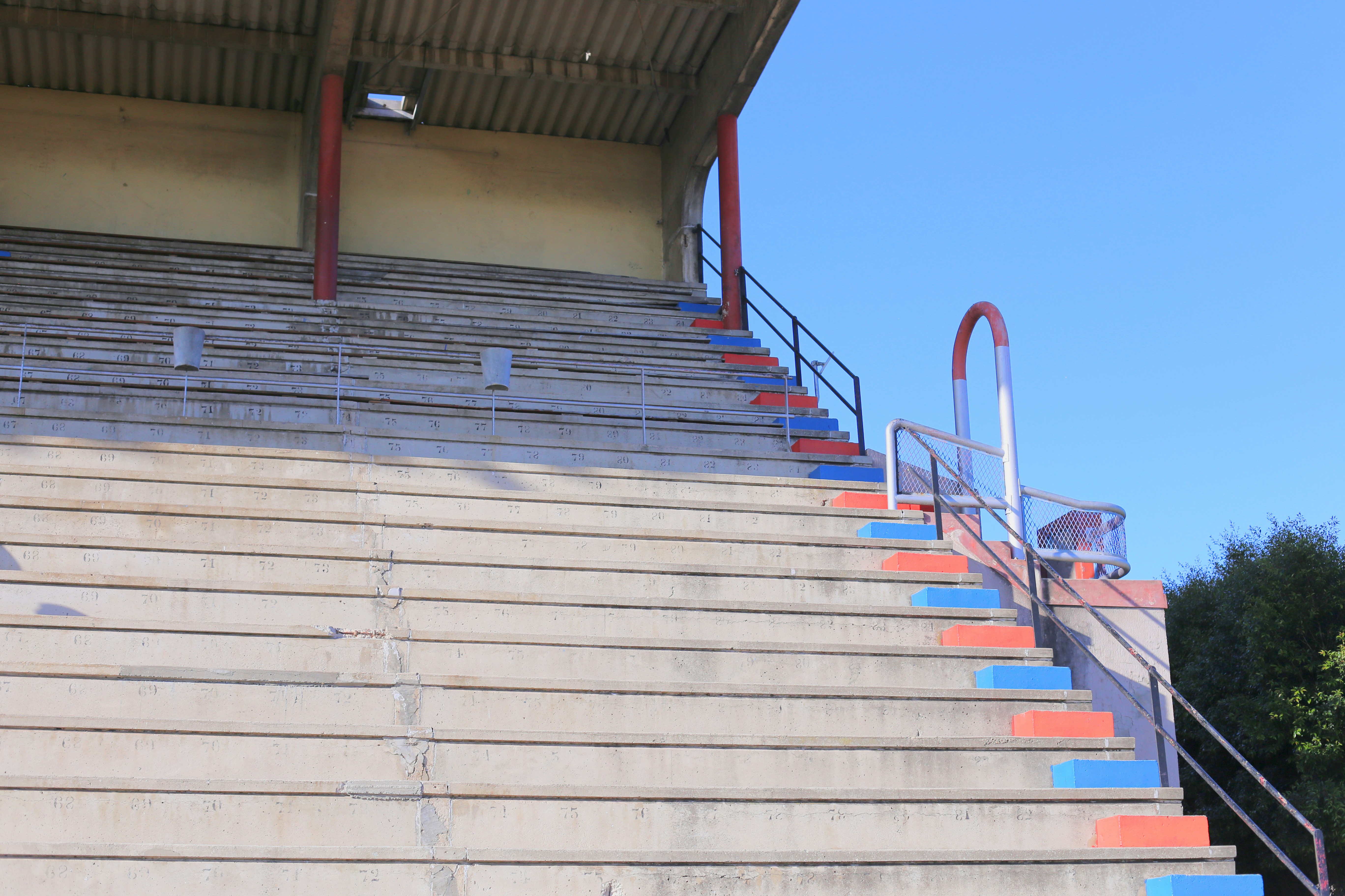 Concrete stadium bleachers with blue and orange accents.