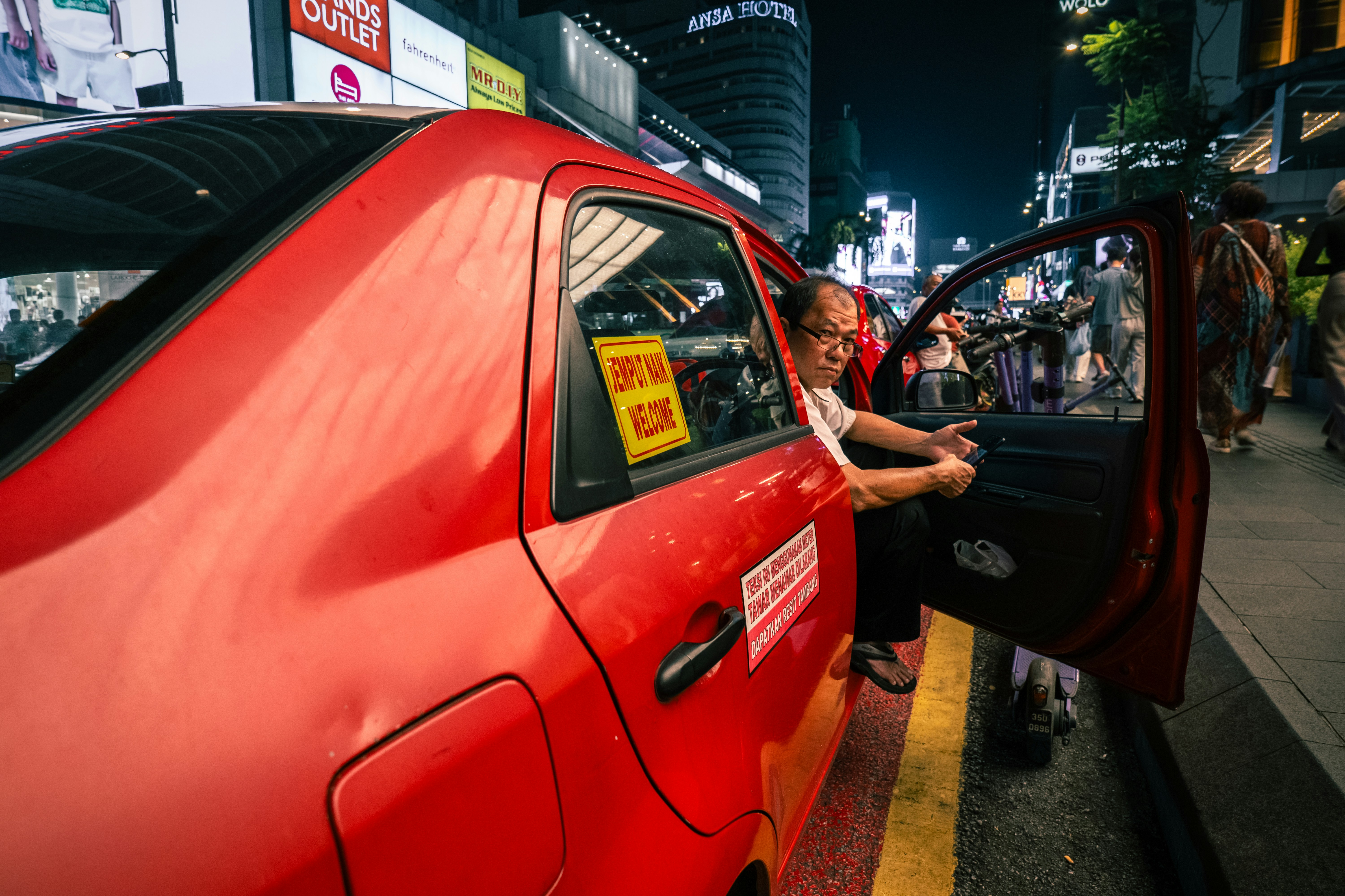 Femme ouvrant la porte rouge de la voiture la nuit
