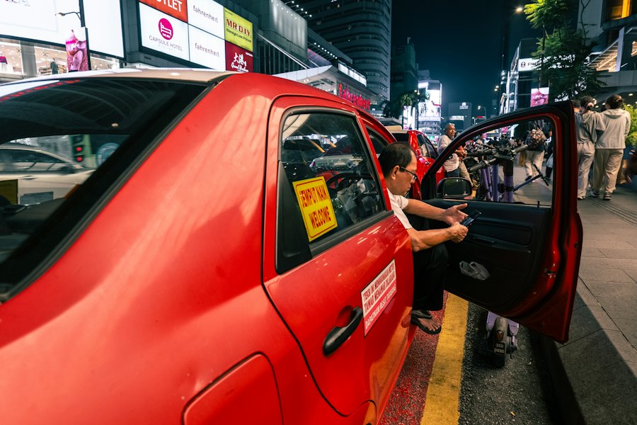 Passenger getting into an e-hailing car at night
