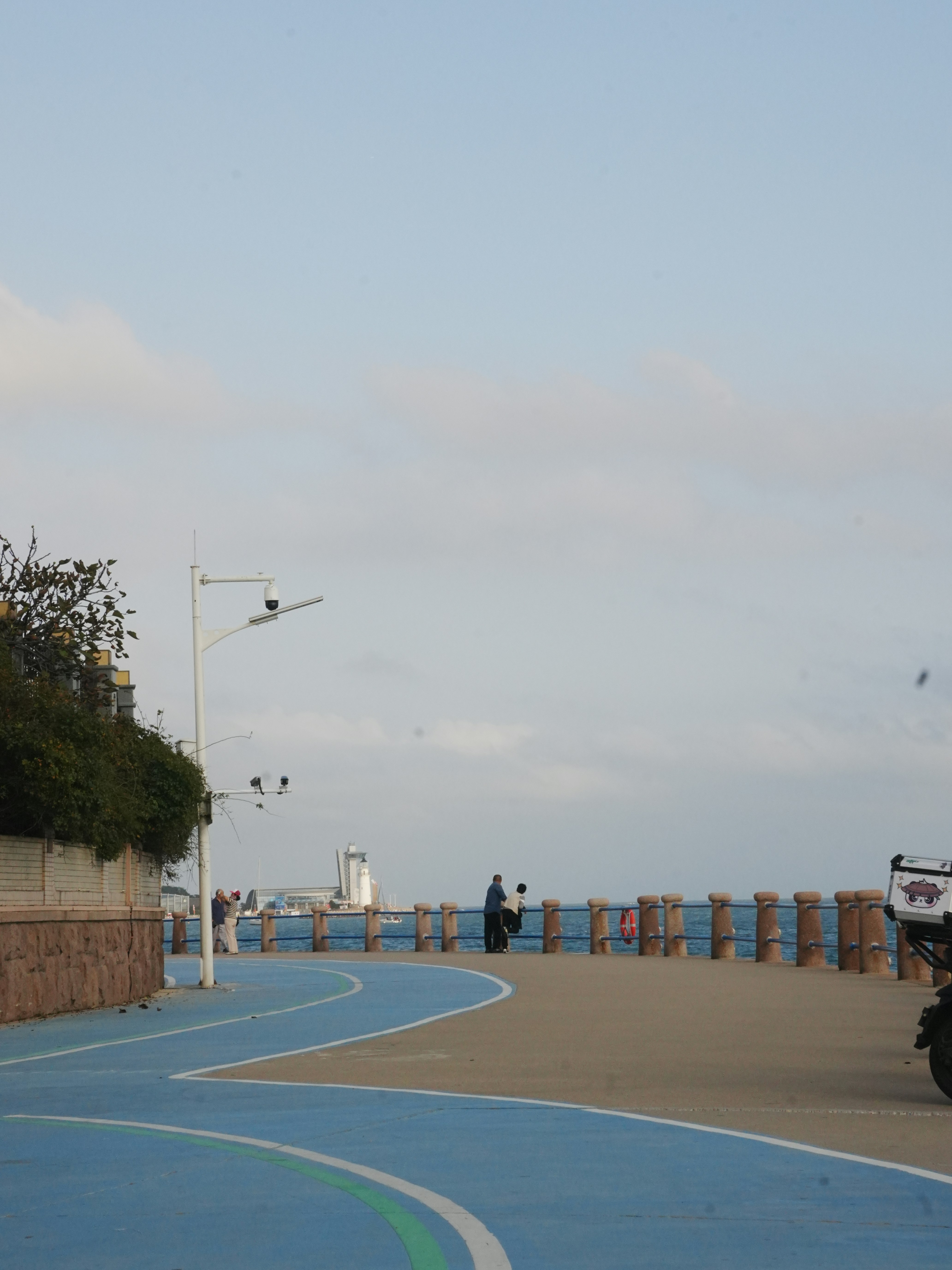 People walking on a scenic coastal promenade.