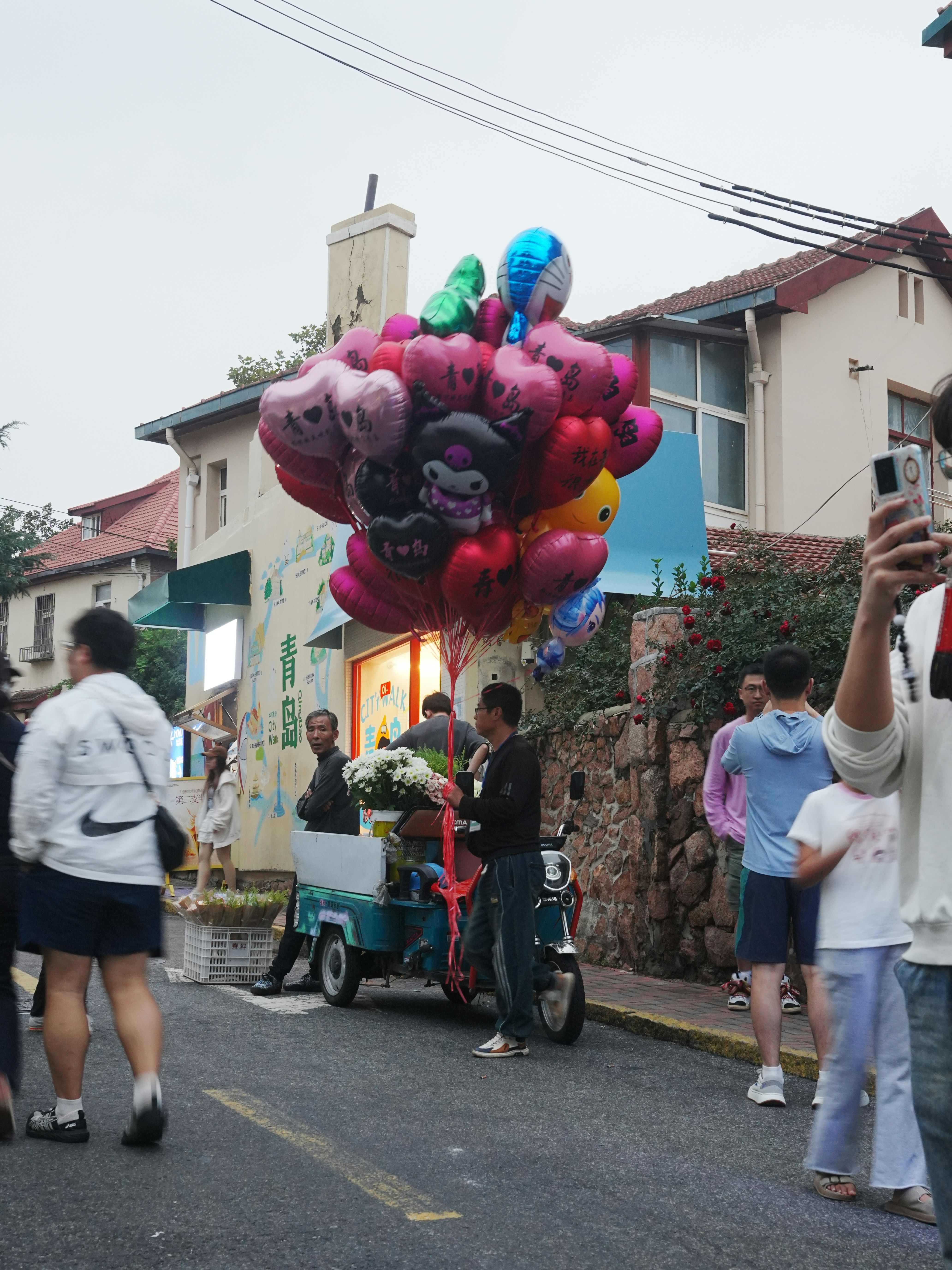 Colorful balloons and flowers on a street cart