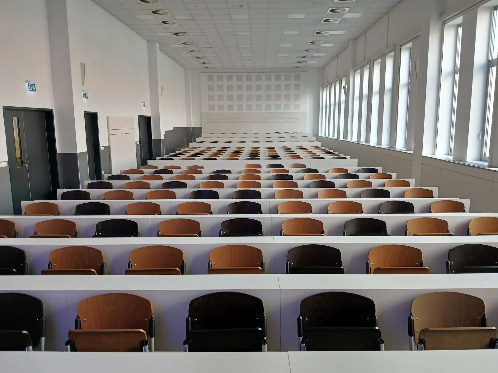Empty tiered lecture hall with rows of seats