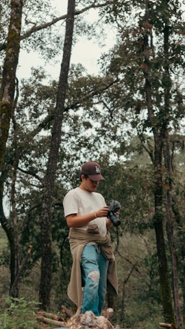 Man holding a camera in a forest