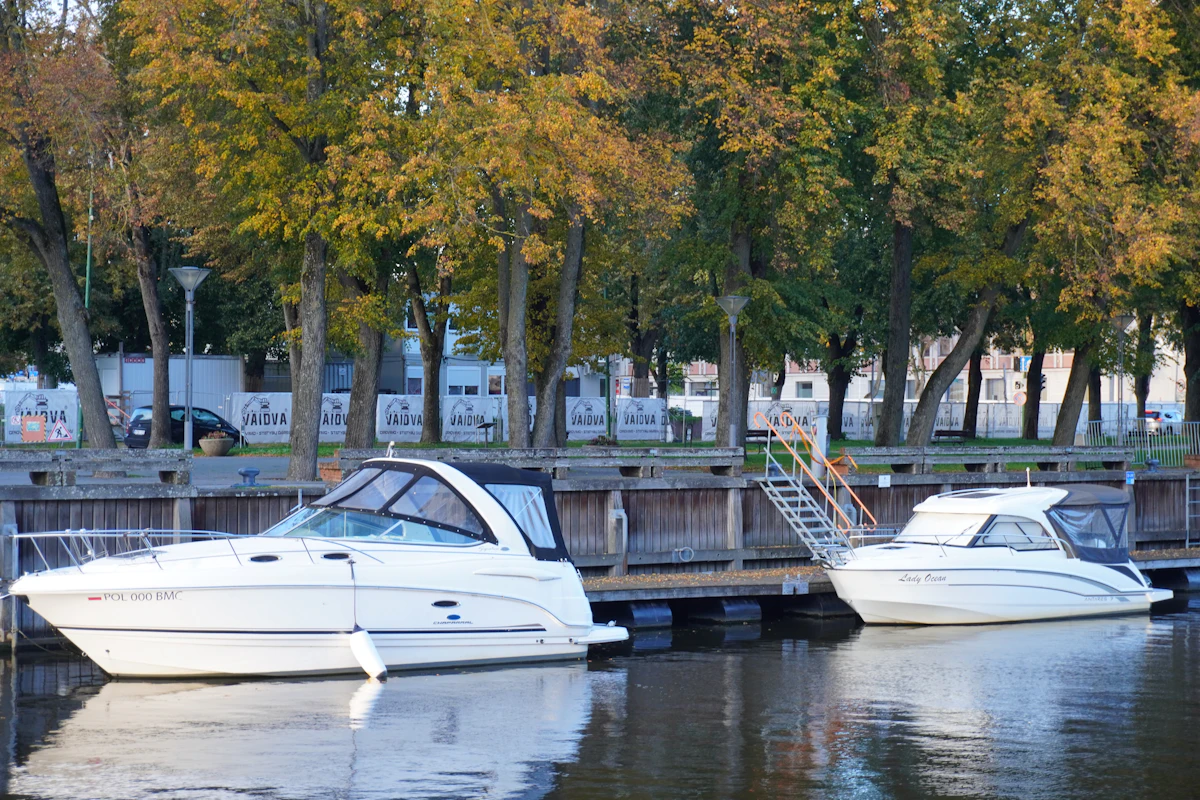 Two freshly detailed white cruisers at a wooden pier