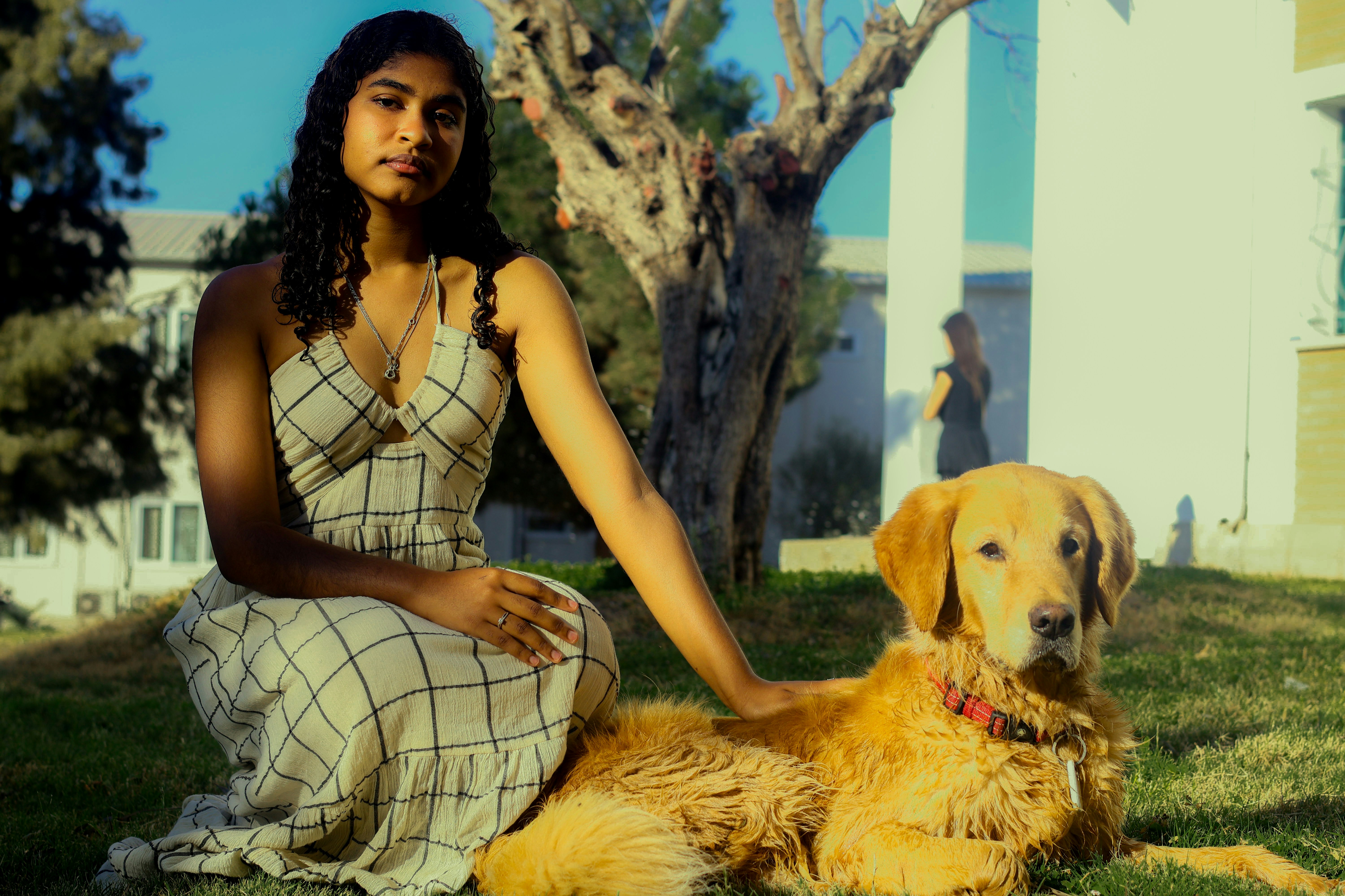 Woman with golden retriever dog in grassy yard