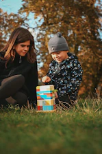 Two children playing with colorful blocks outdoors.