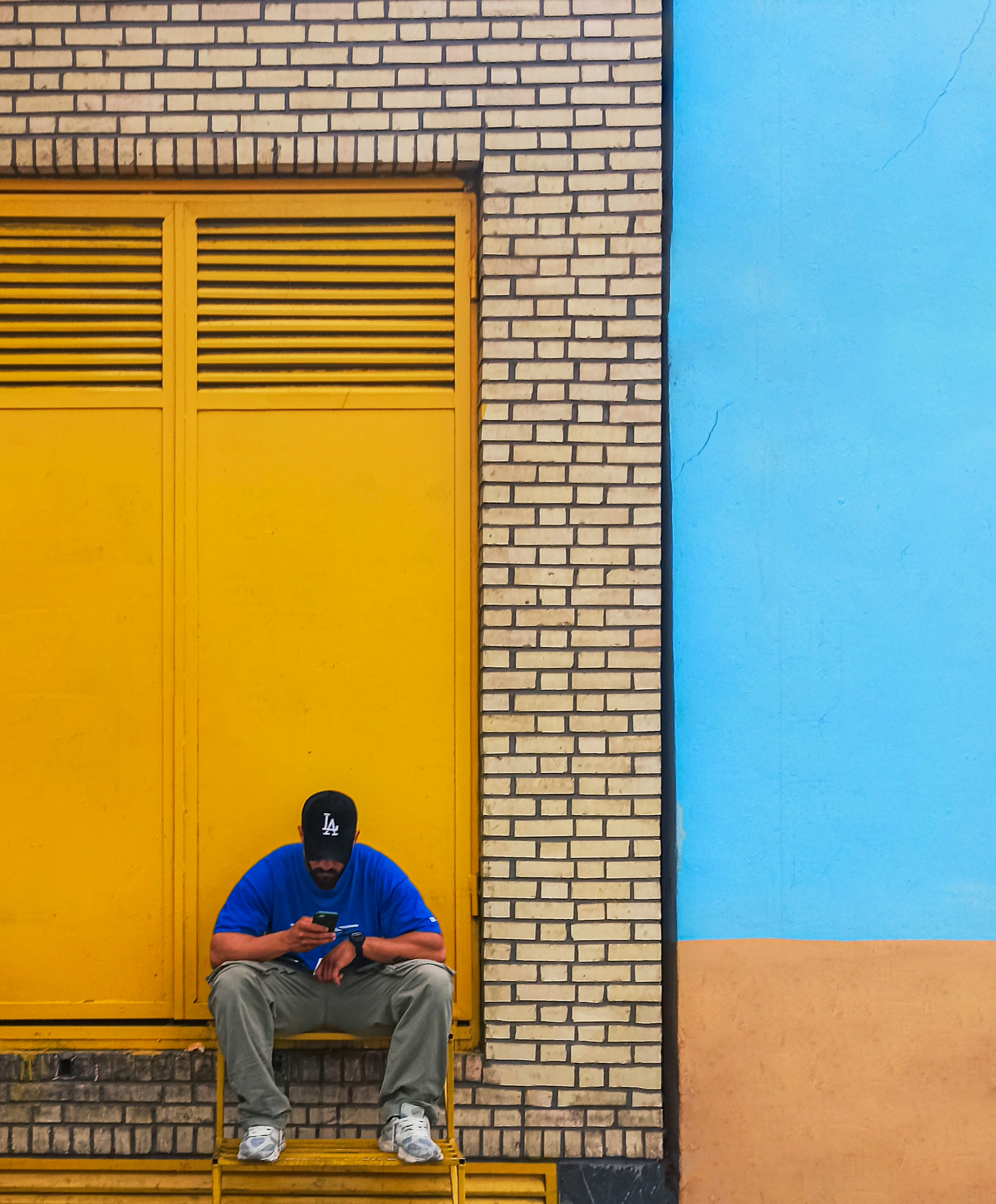 Man sits on steps using his phone.