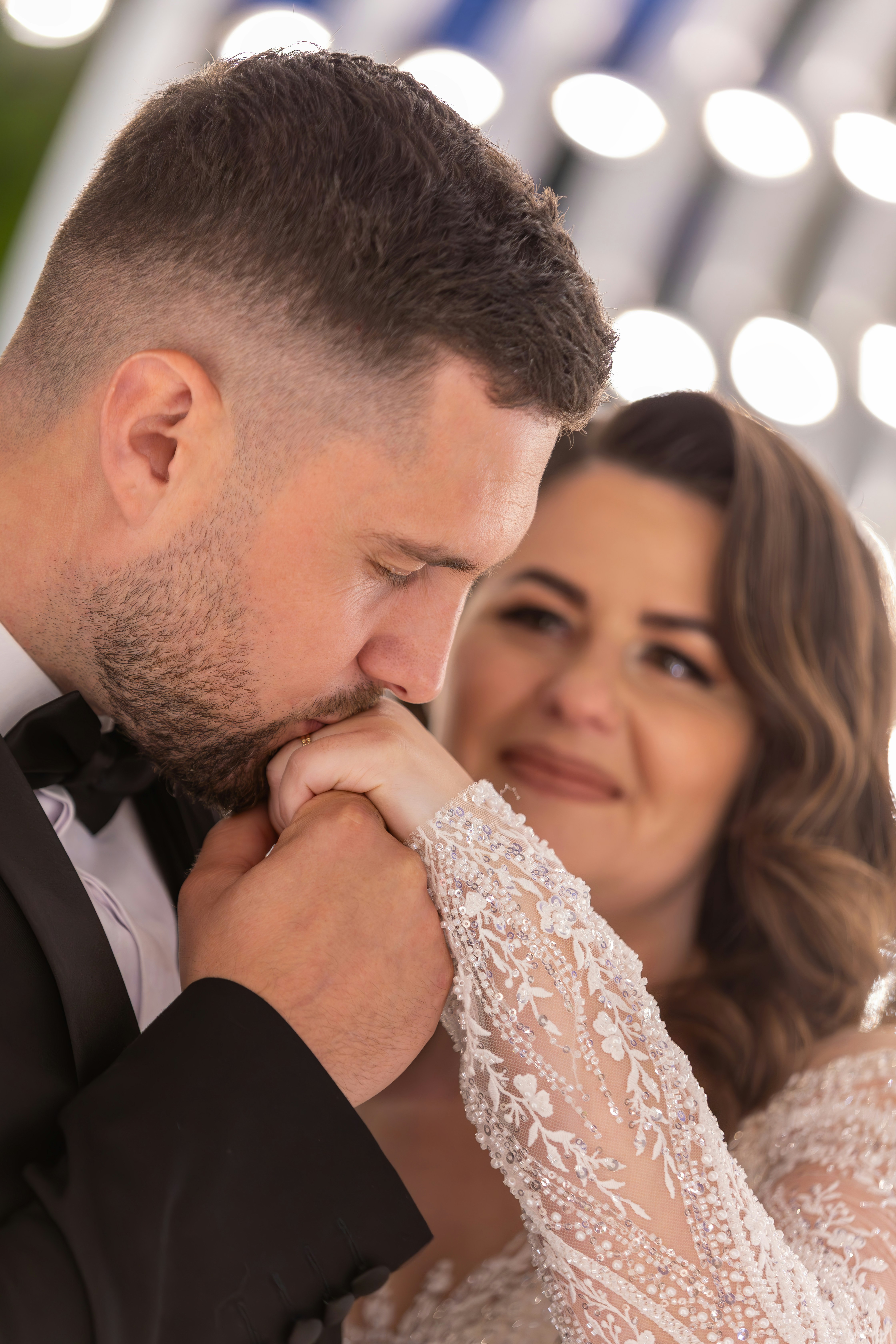 Pengantin pria mencium tangan pengantin wanita di pernikahan