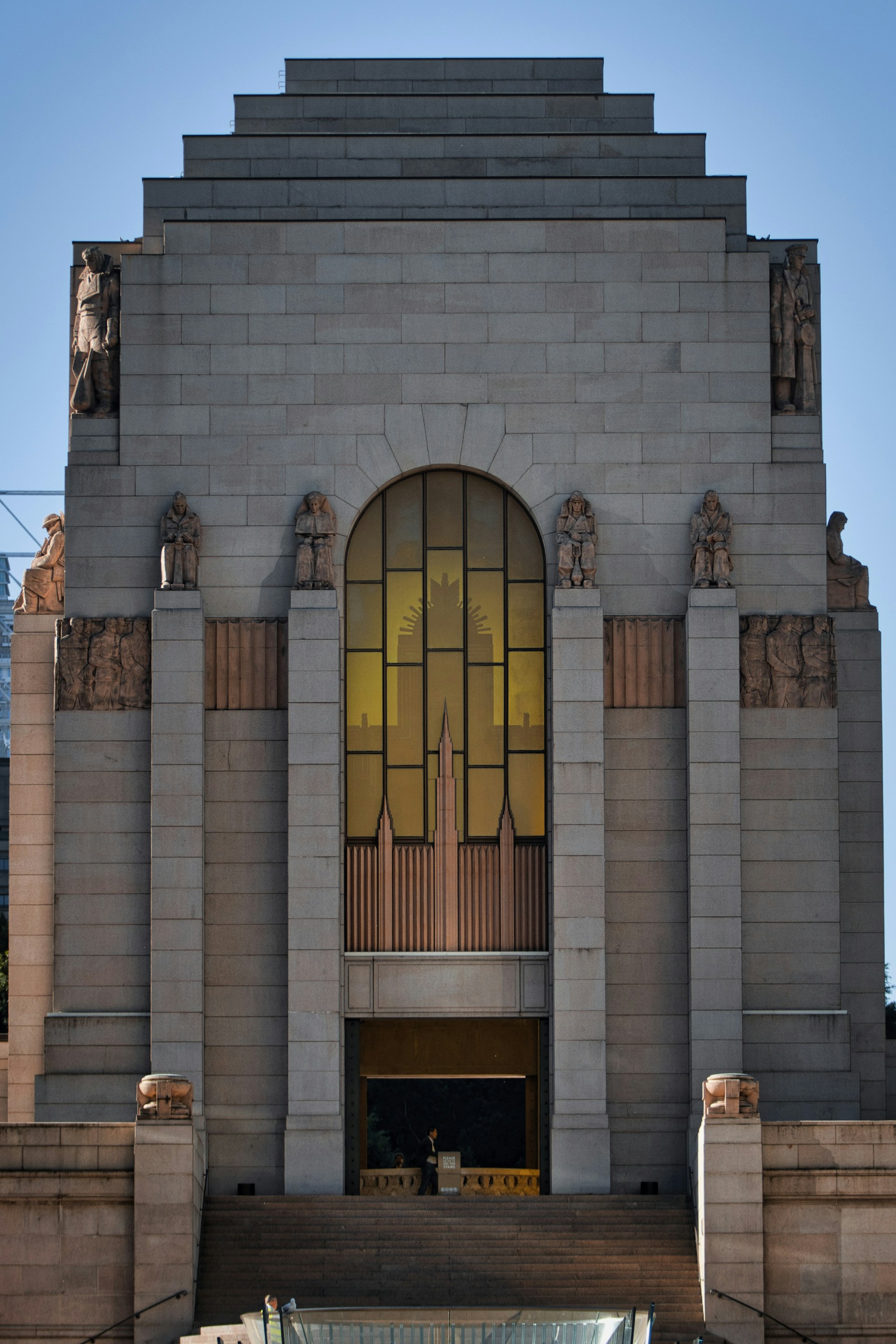 Grand stone building with arched window and statues