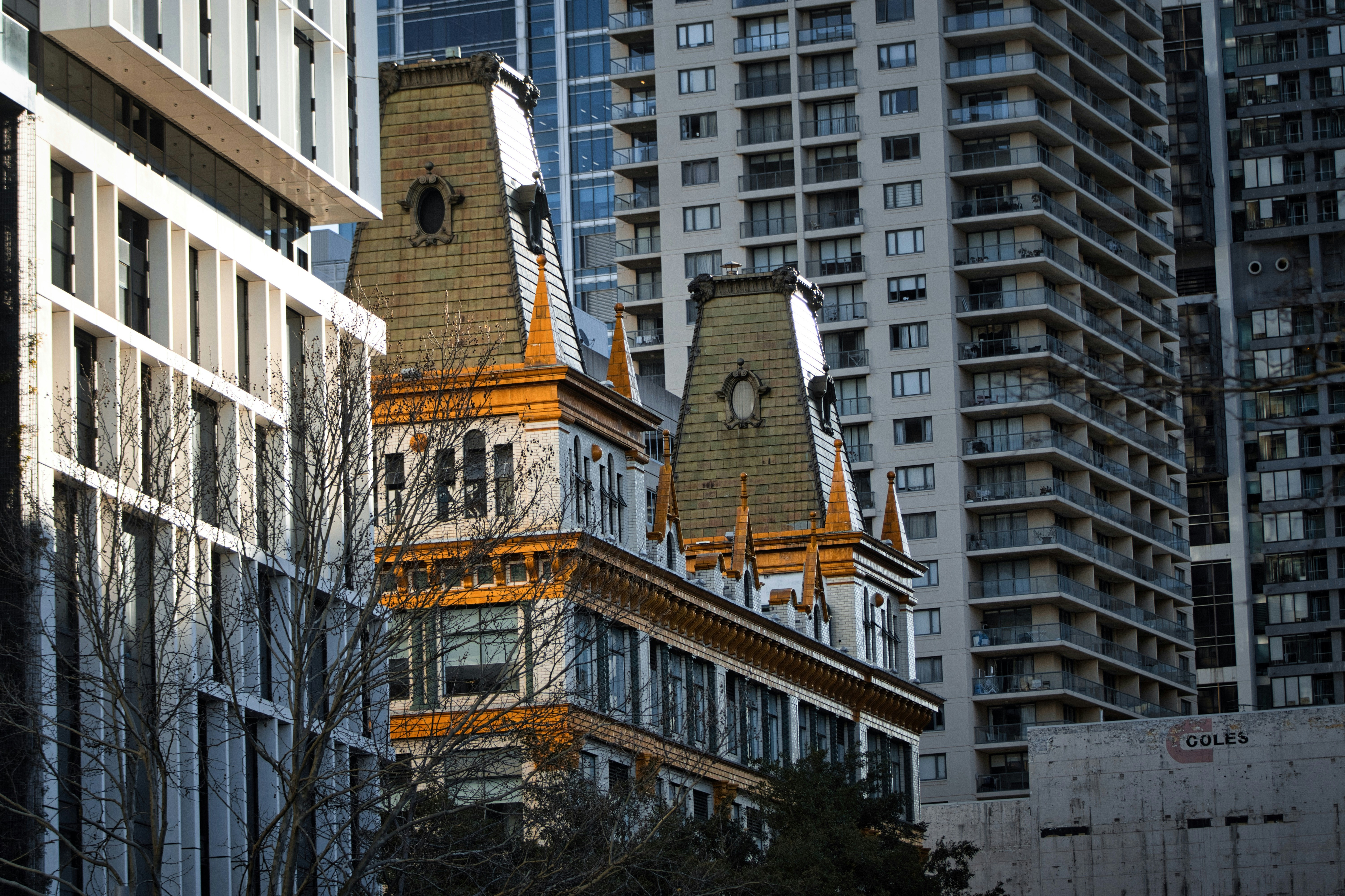 Ornate historic building surrounded by modern skyscrapers