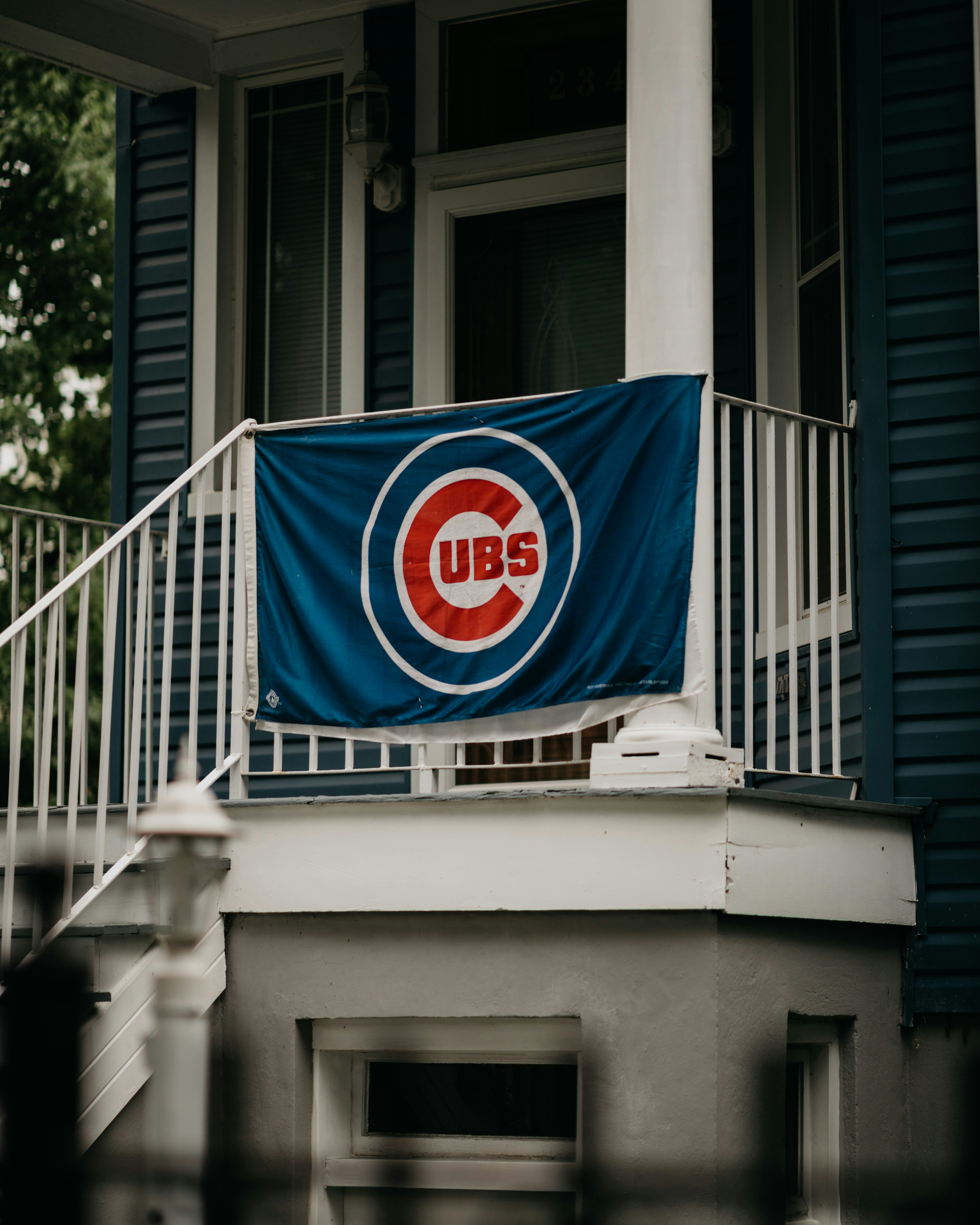 Chicago cubs flag on a porch railing.