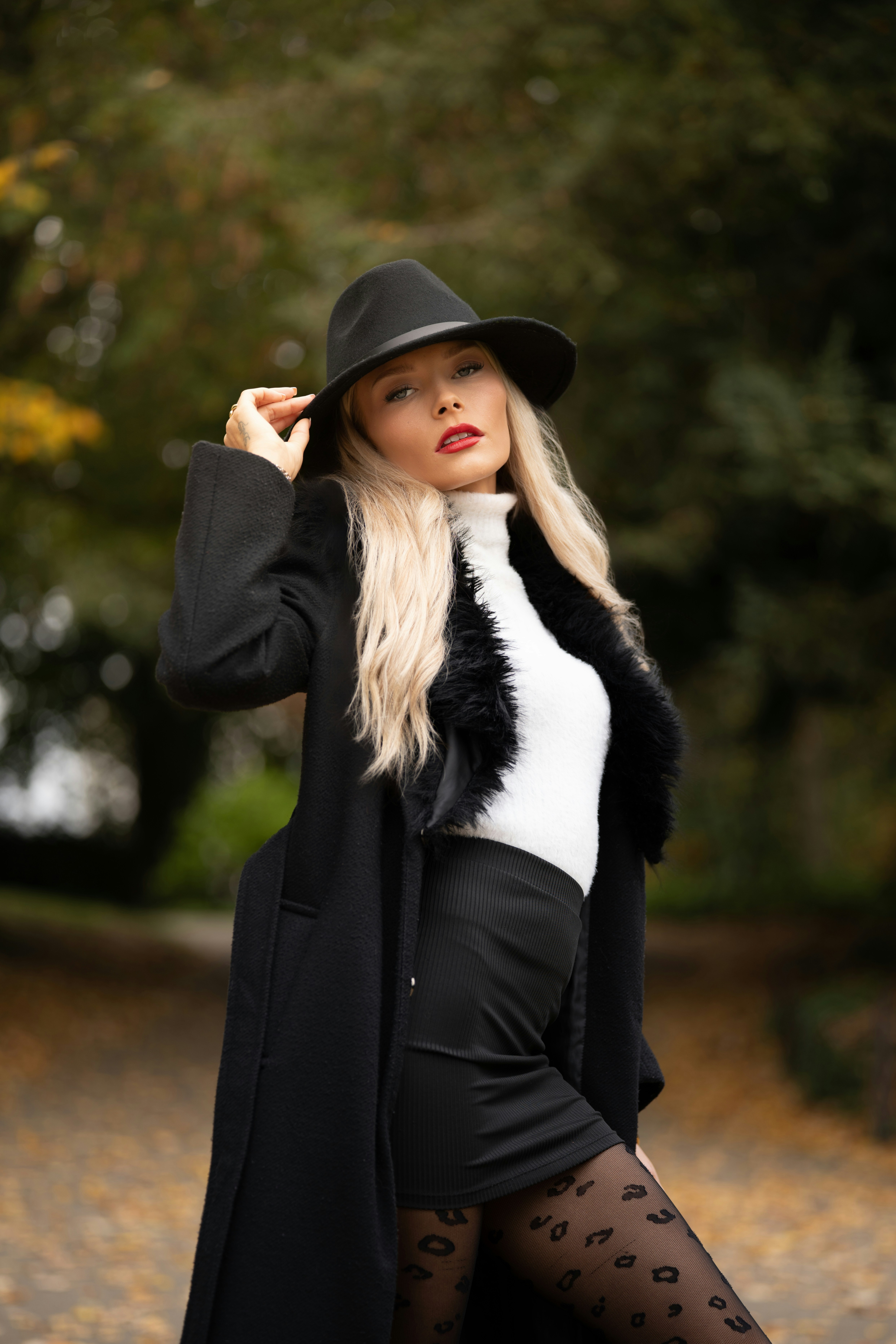 야외에서 검은 코트와 모자를 쓴 여자