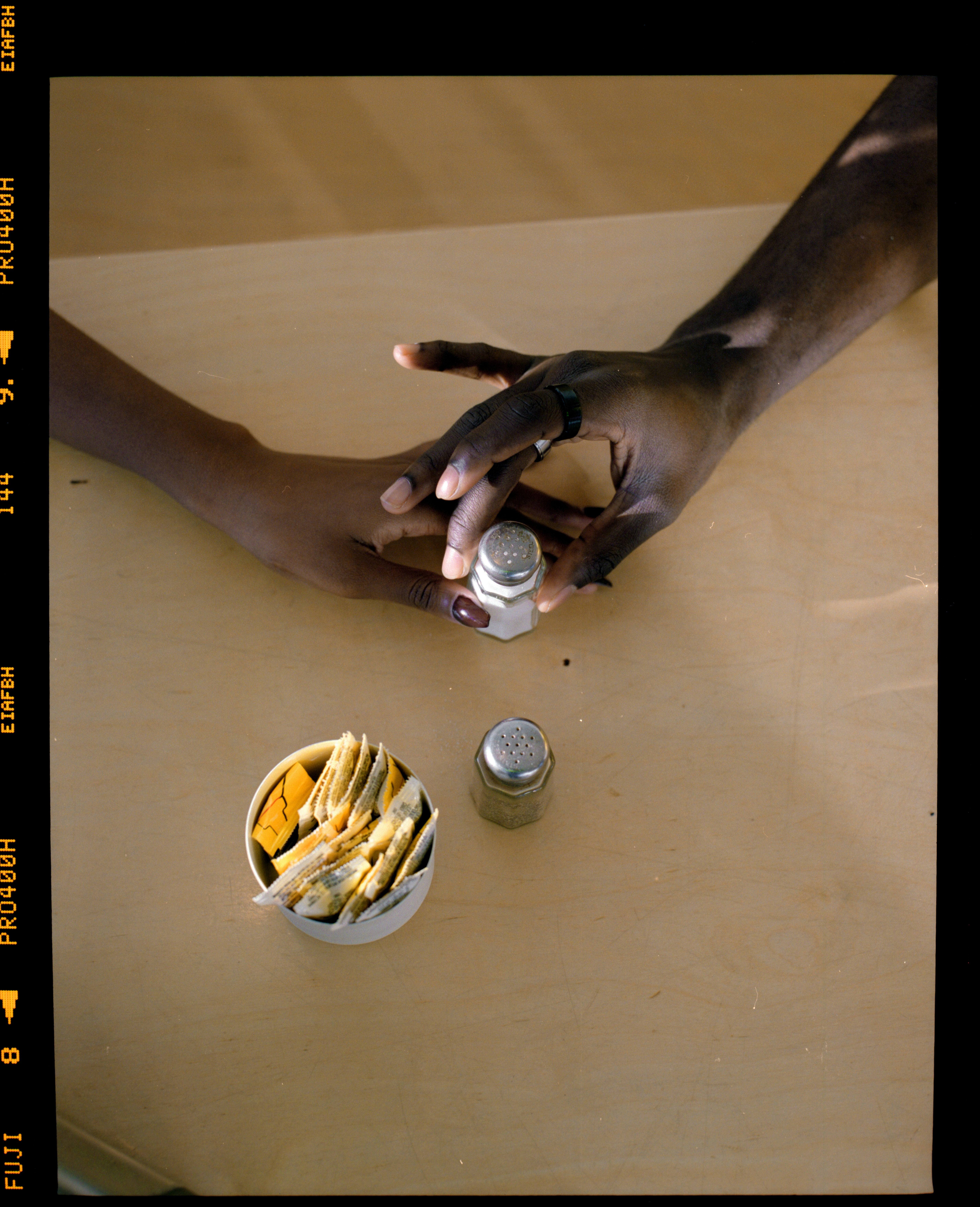 Zwei Hände greifen nach Salz- und Pfefferstreuern