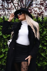 Woman in black coat and white sweater