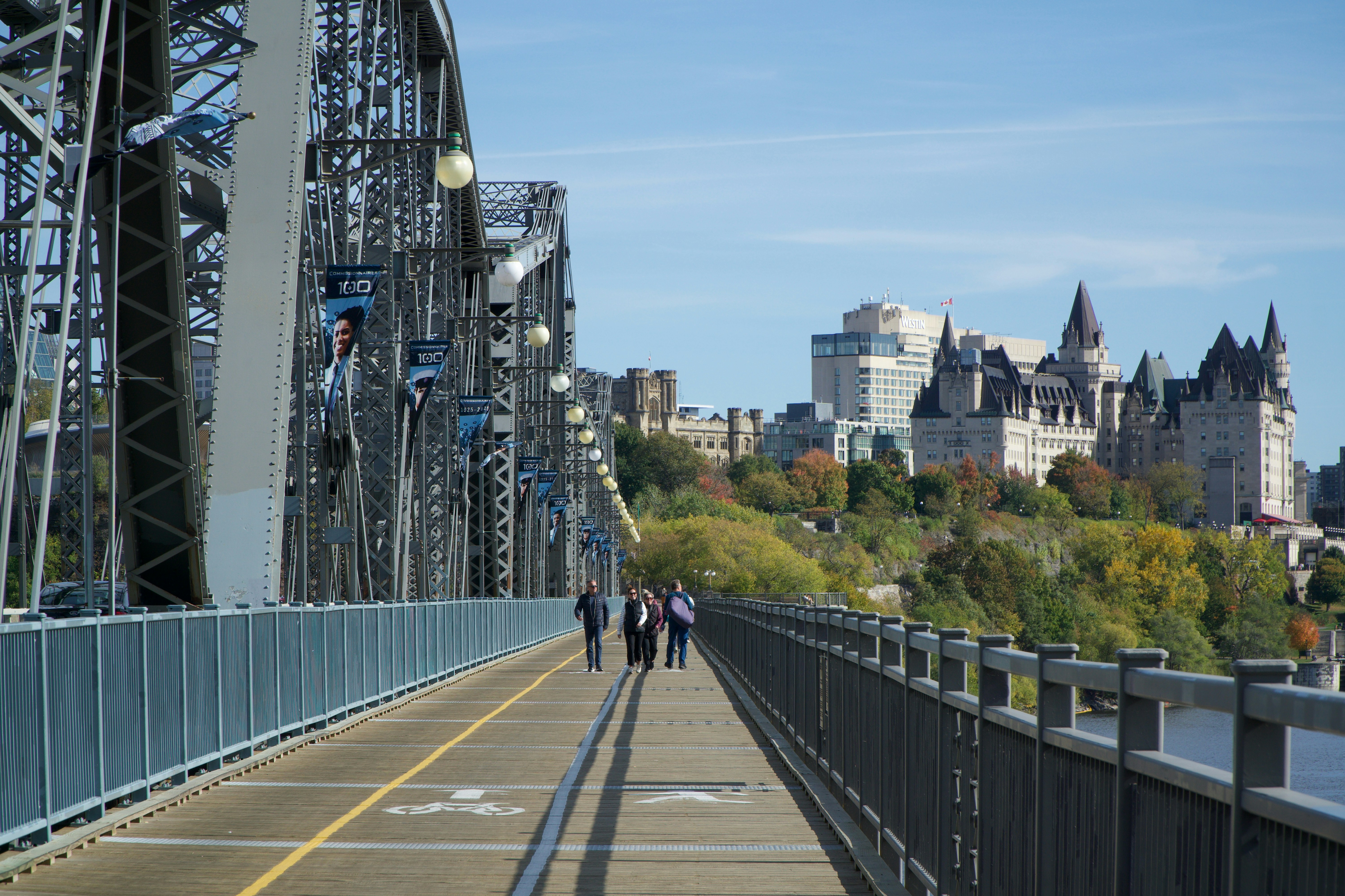 People walking on a bridge towards a castle-like building.