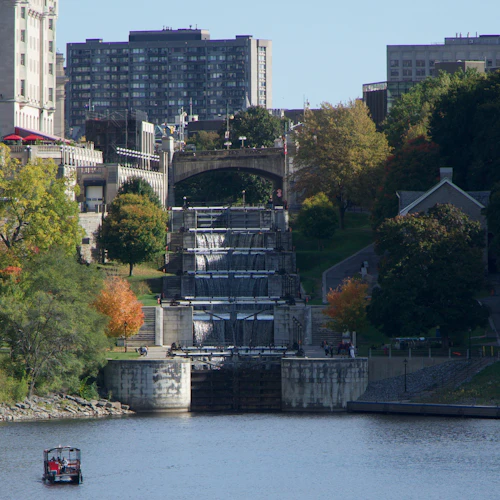 Water cascading down the stone Rideau Canal locks in Ottawa beside autumn trees