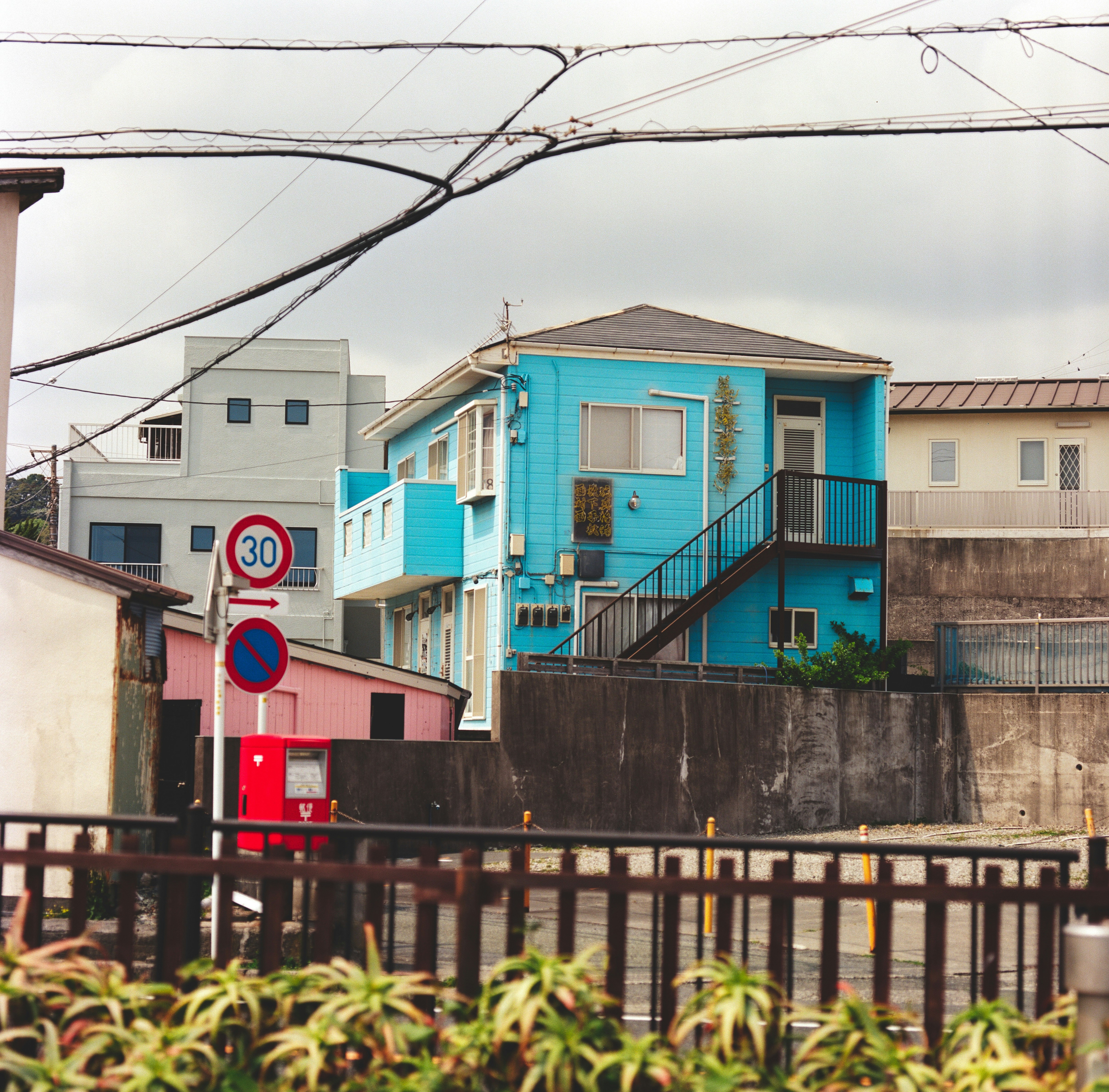 Edificio azul brillante con escaleras y letreros en las calles.