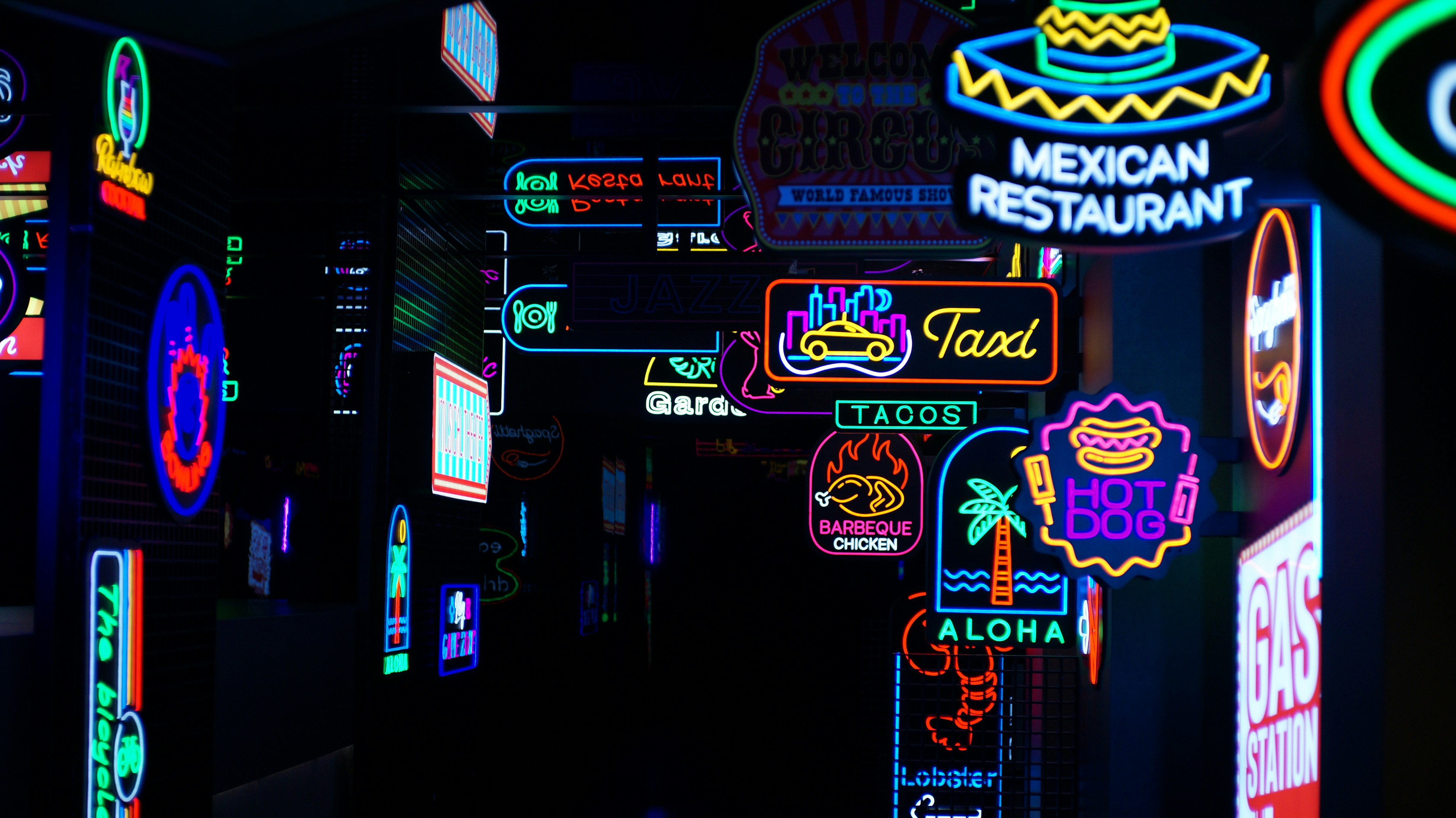 Vibrant neon signs illuminate a dark city street at night