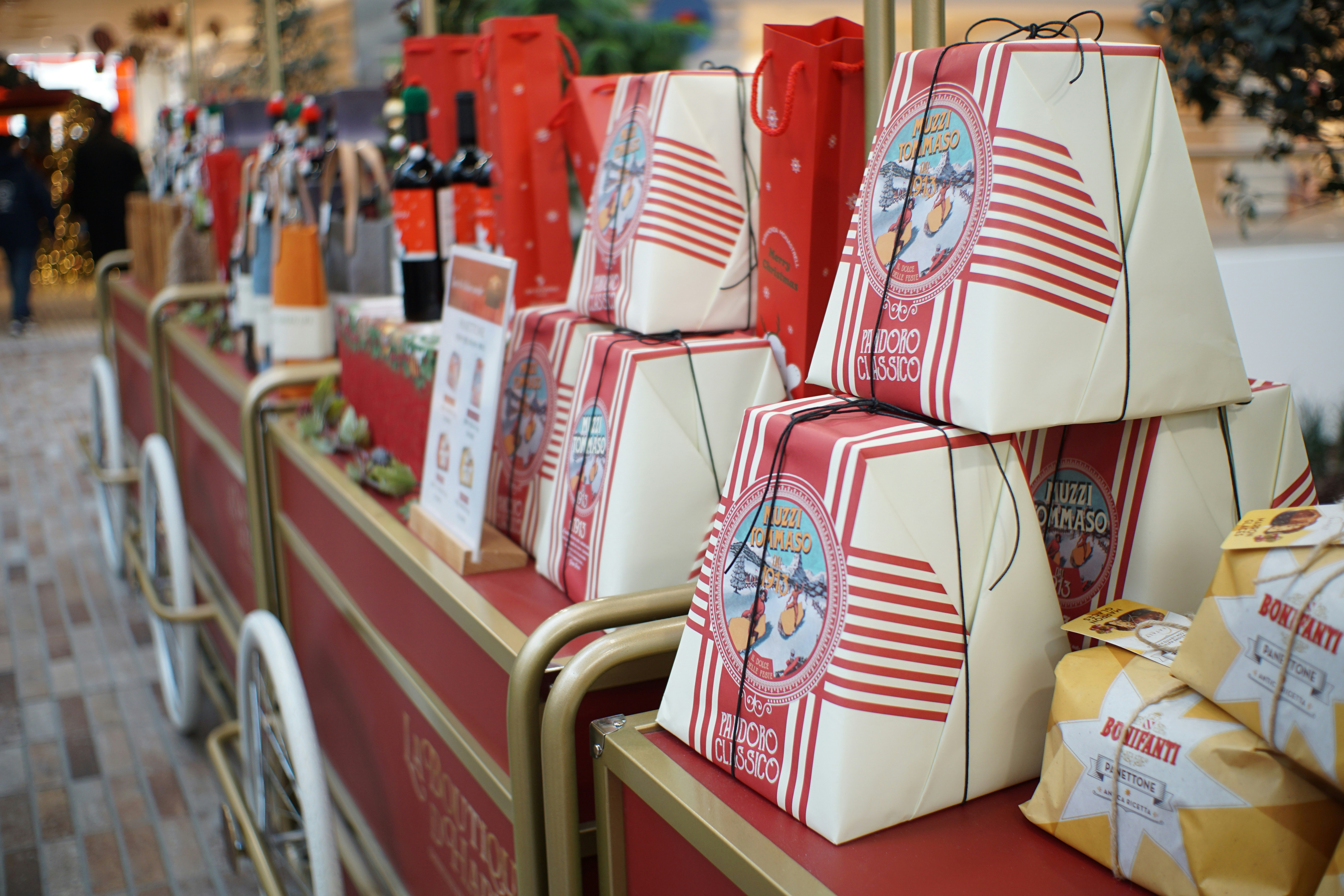 Regalos navideños envueltos apilados en un carrito festivo.