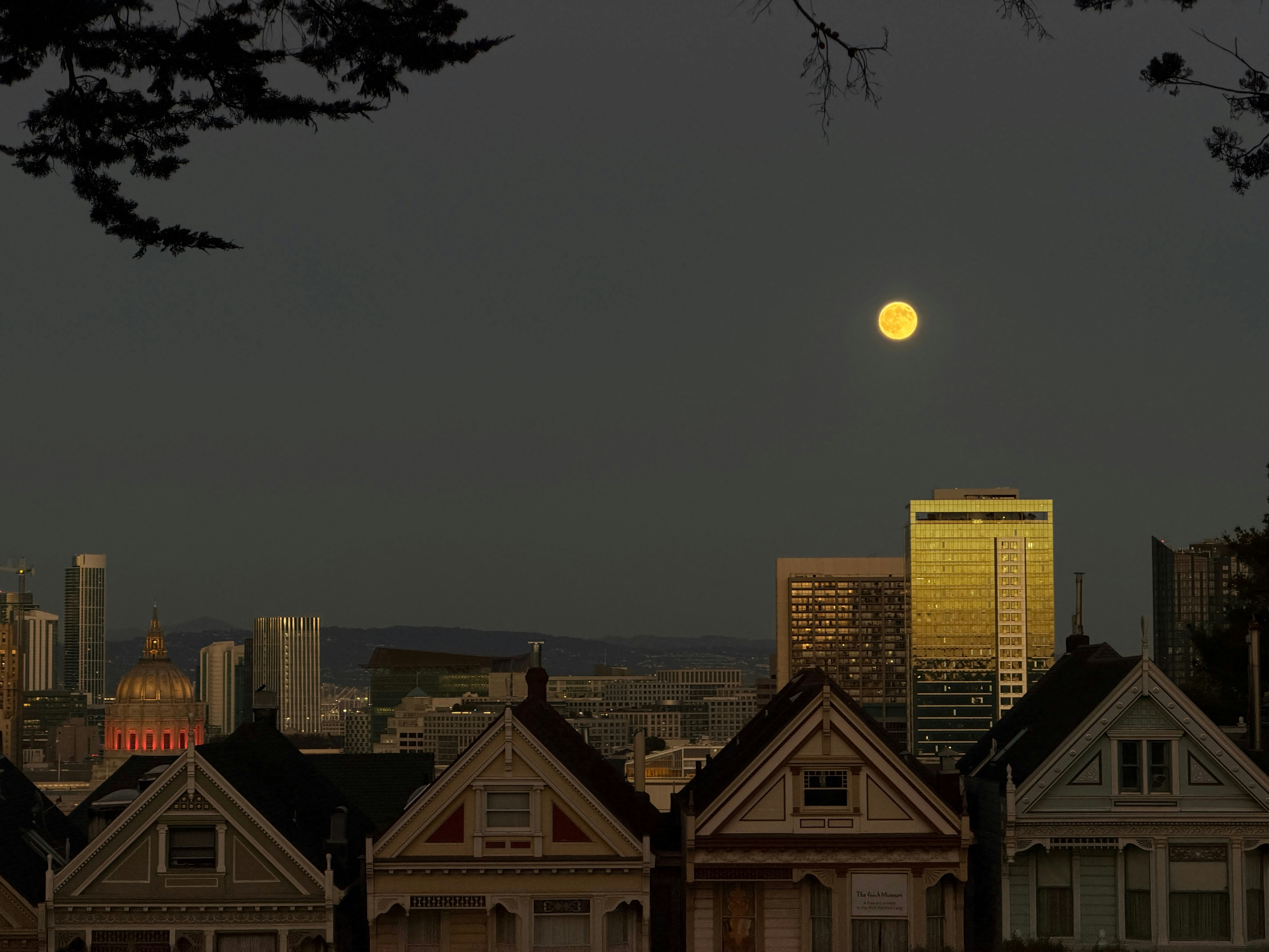 Full moon over painted ladies and city skyline