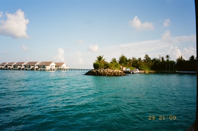 Overwater bungalows line a tropical island shore.