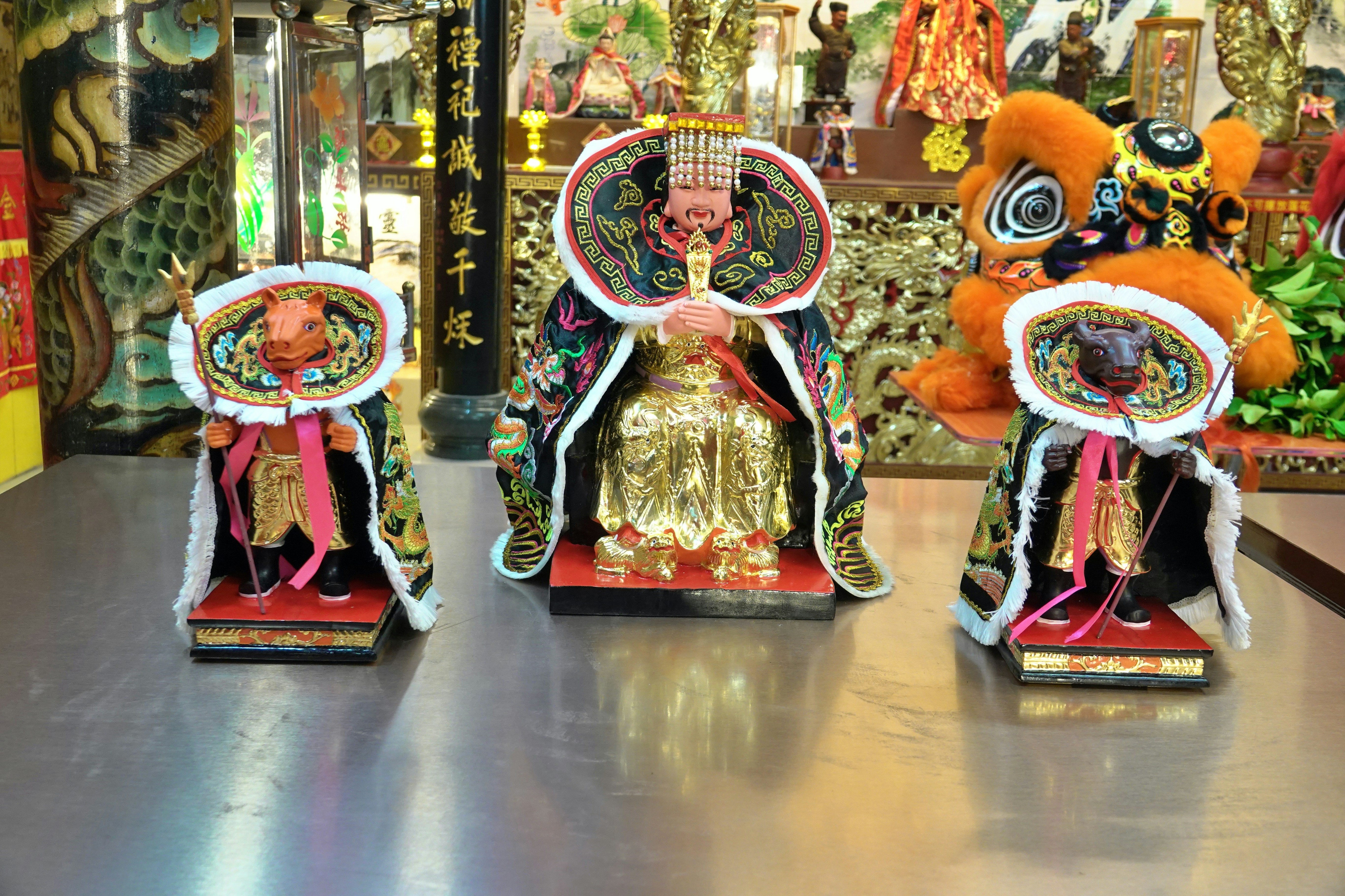 Three ornate figures in a temple setting