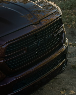 Close-up of a dark red ram truck grille.