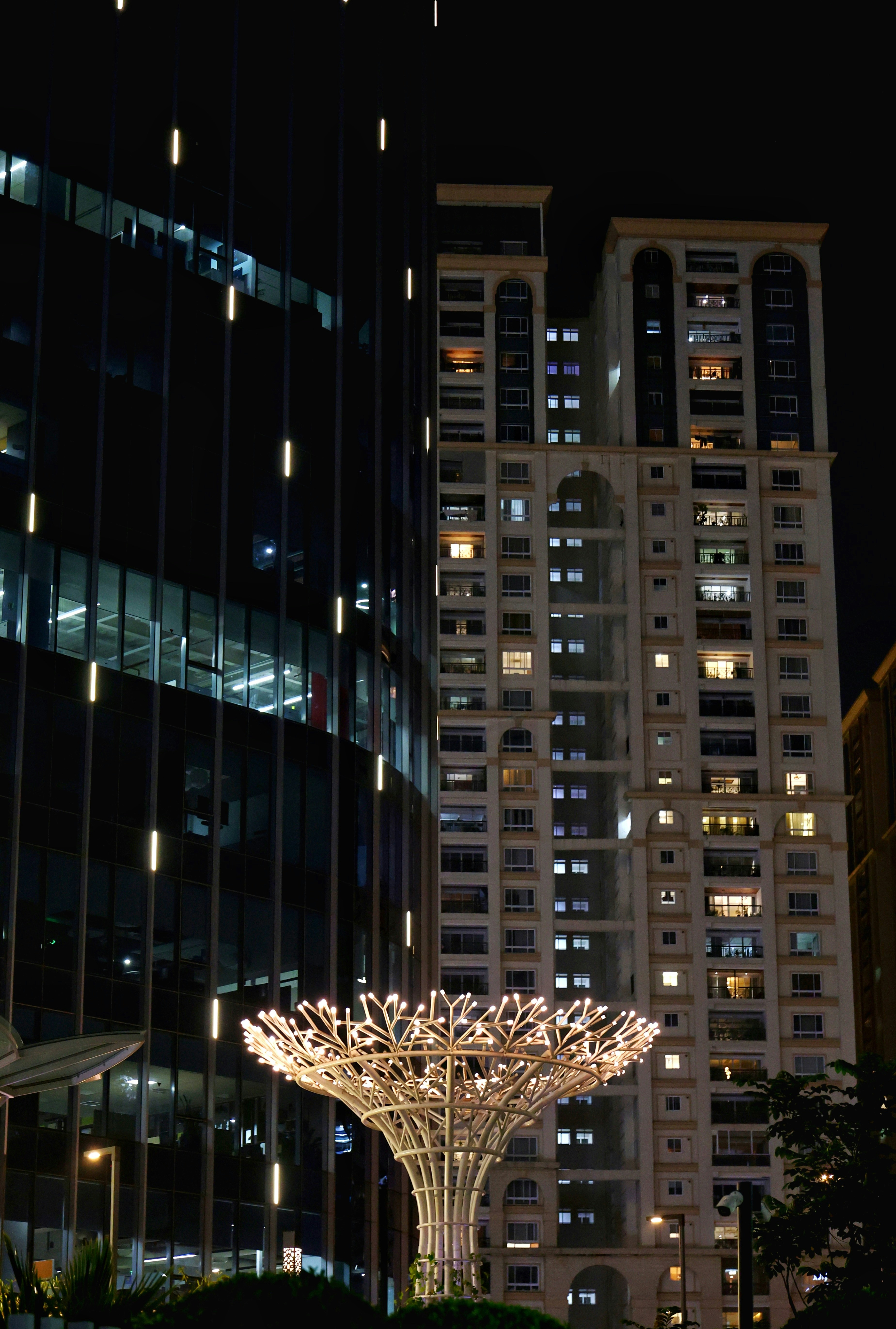 Bangunan modern dan patung bercahaya di malam hari